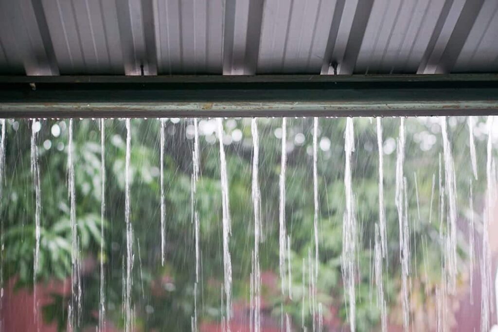 Rain dripping off the underside of a corrugated metal roof
